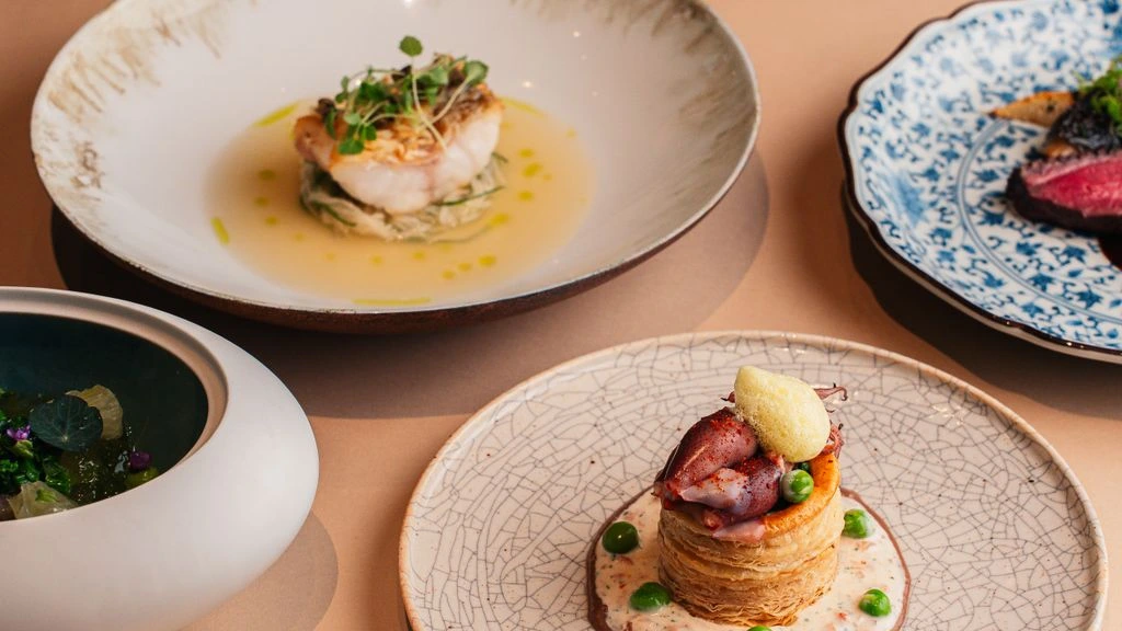 The pass of a fine-dining restaurant showing a line of finished desserts