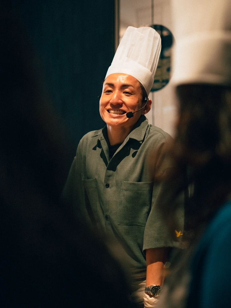 A Chez Claudy chef guiding a student through laminating croissant dough
